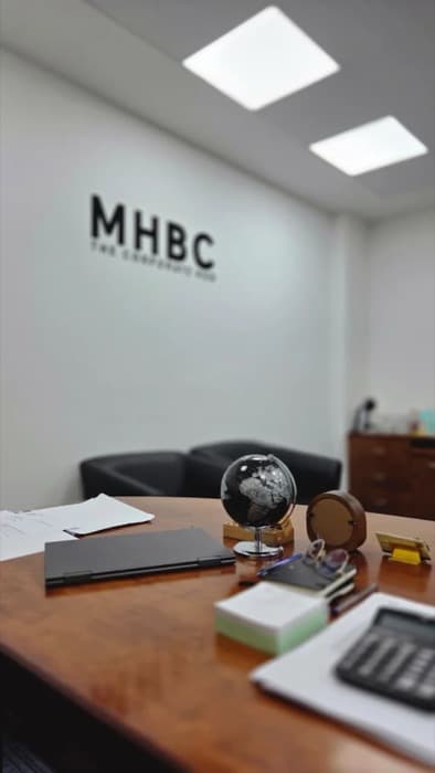 A consultant at the office window, Sharjah skyline behind