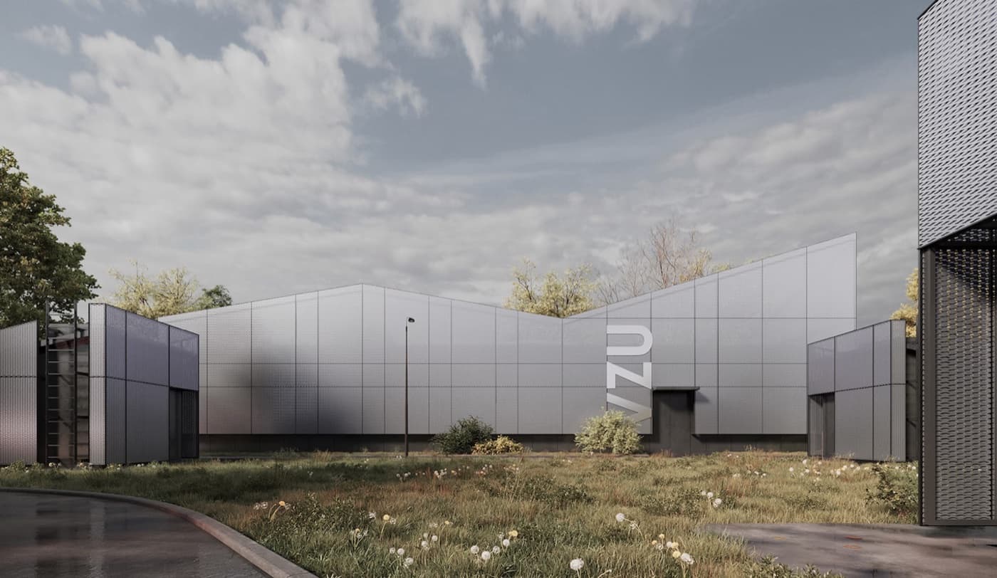 A grey metal-panelled institutional building under a broad sky