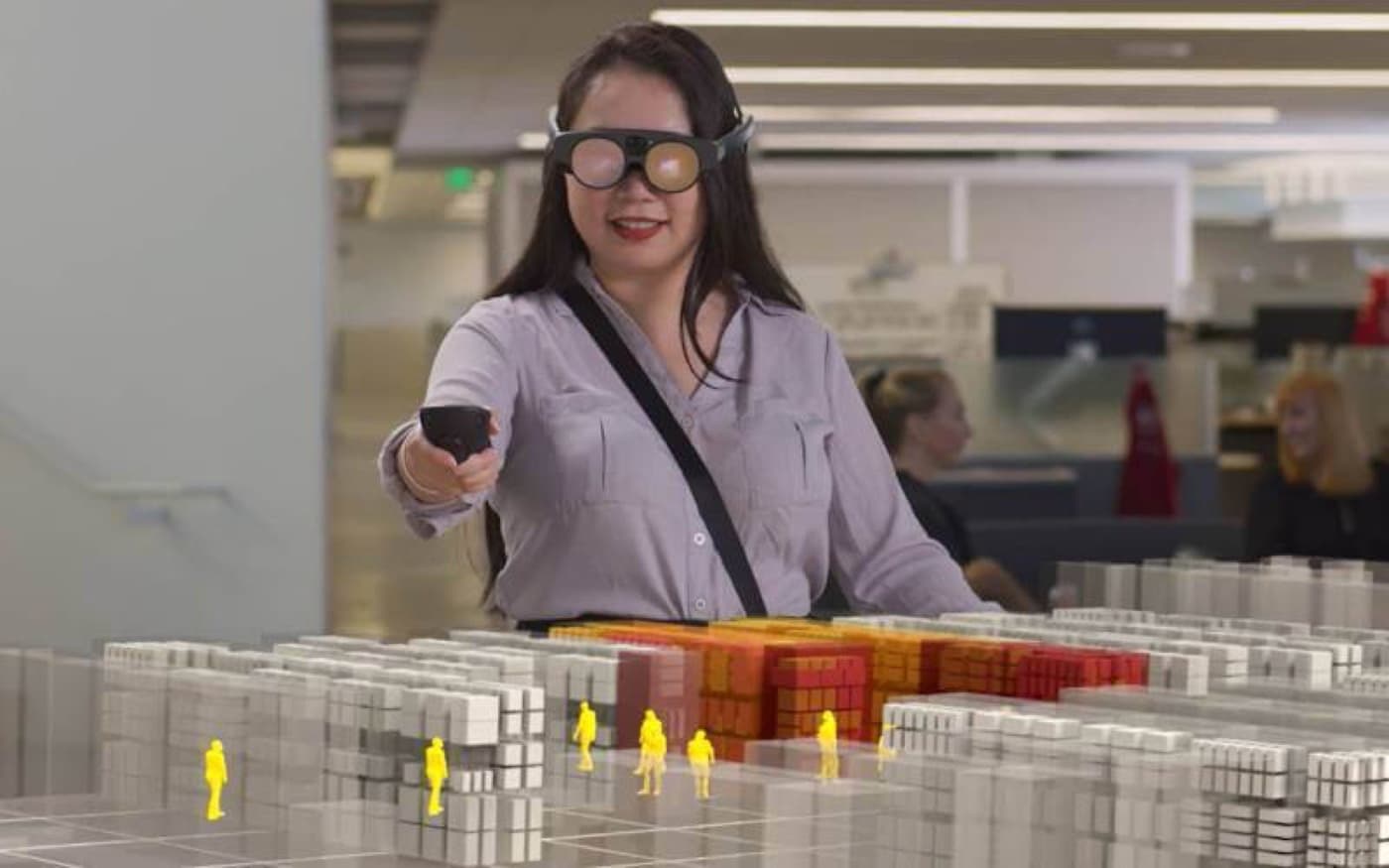 A person reviewing a scale model of a city block laid out in blocks