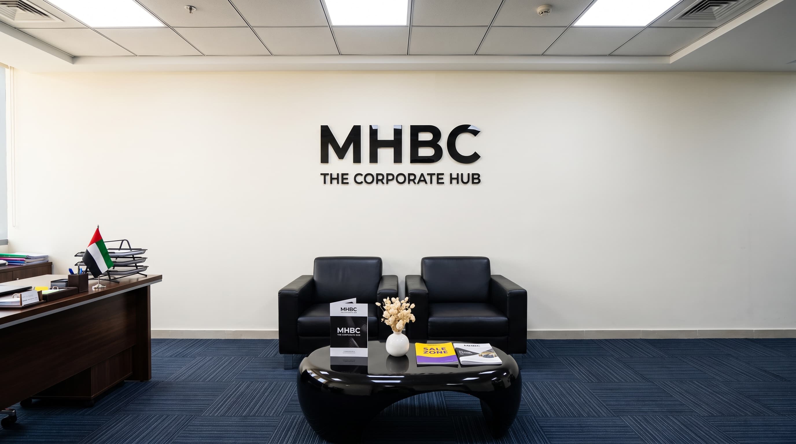 The MHBC reception — the company wall sign above black armchairs and a low table.